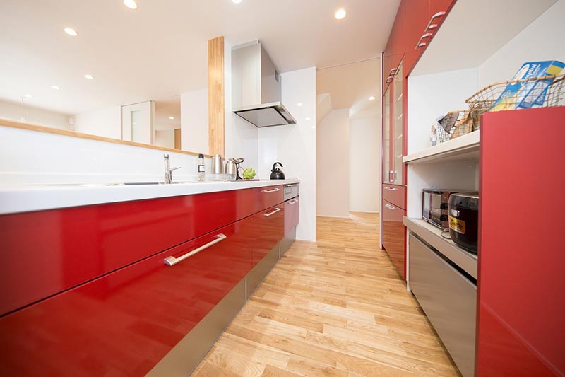 赤いキッチンが印象的な1階のLDK